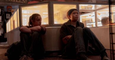 Bella Ramsey as Ellie (left) and Storm Reid as Riley (right) sitting next to a bed in the HBO The Last of Us Episode 7: Left Behind