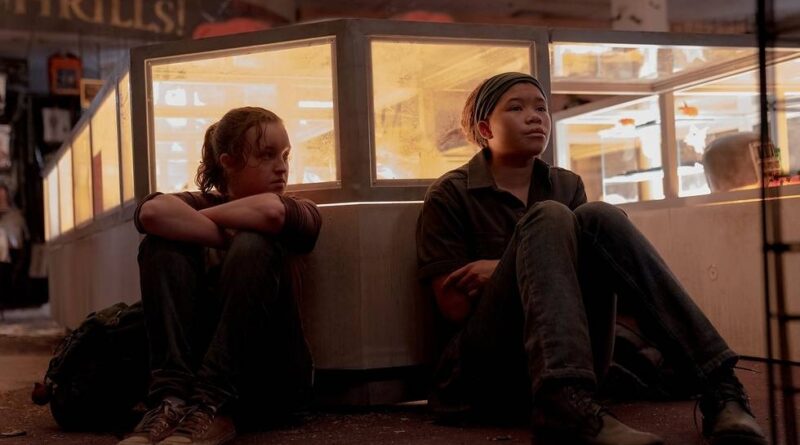 Bella Ramsey as Ellie (left) and Storm Reid as Riley (right) sitting next to a bed in the HBO The Last of Us Episode 7: Left Behind