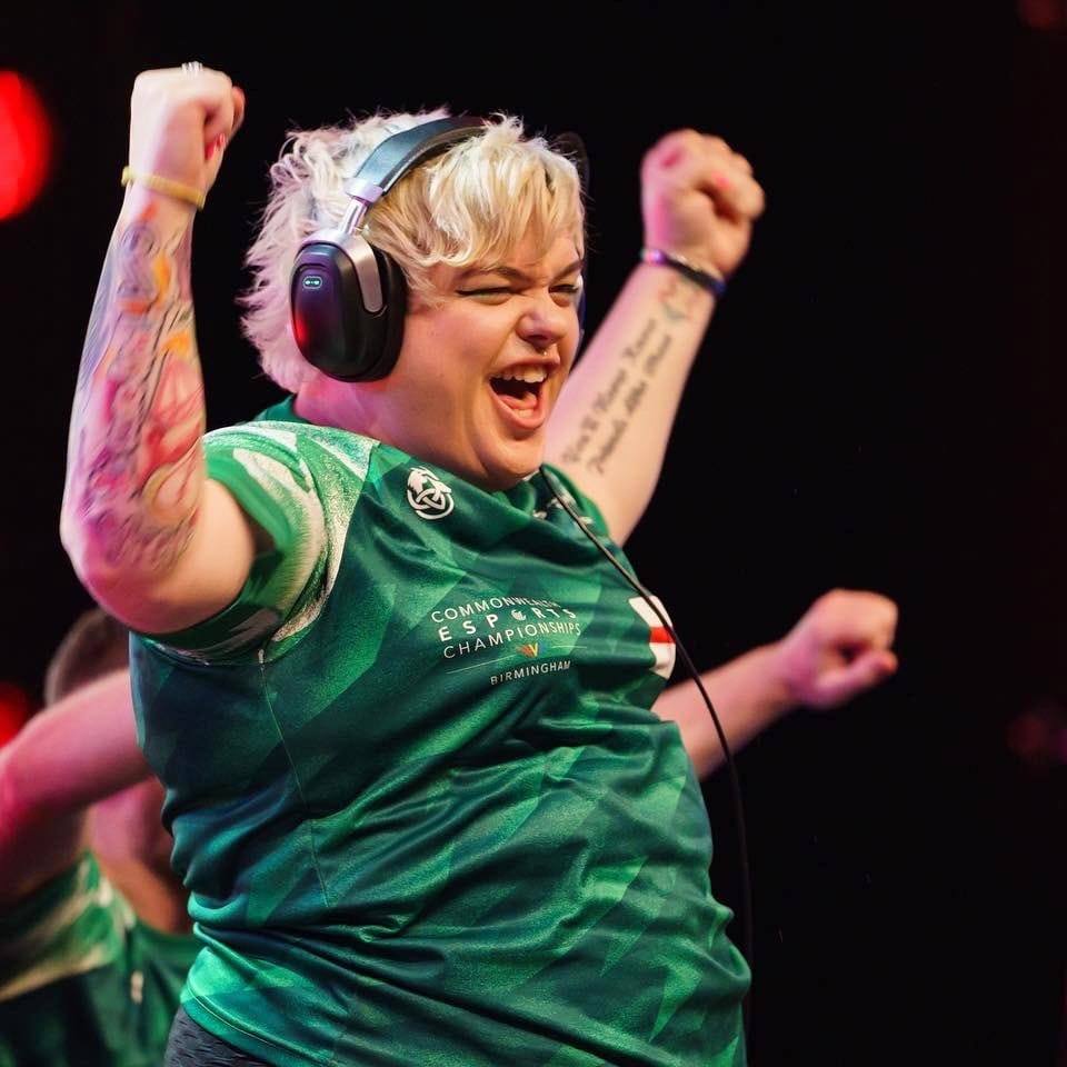 Photo of Emma Rose celebrating a win while wearing her green commonwealth esports championships jersey for Northern Ireland