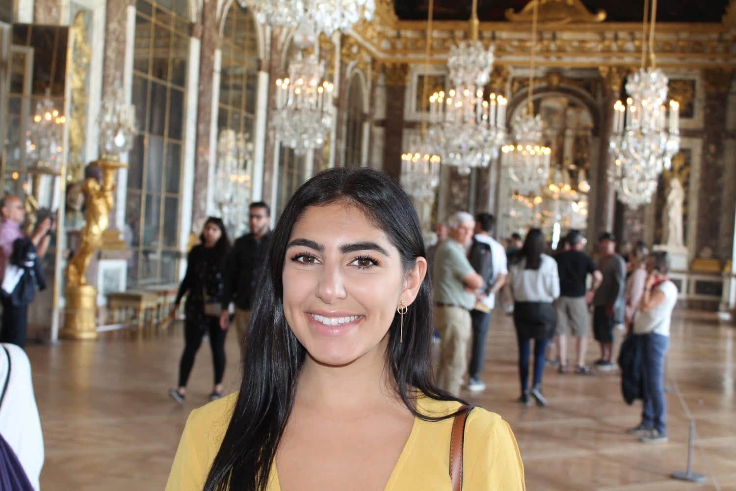 Photo of Kathleen in front of a bunch of chandeliers